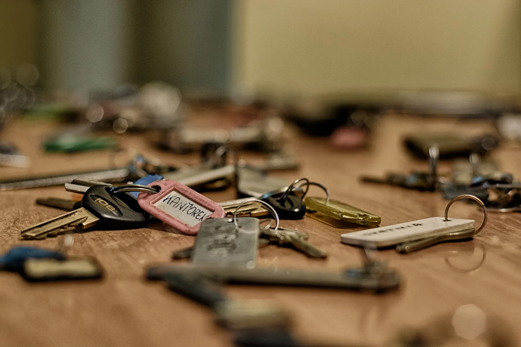 A scattered set of keys on a warm wooden table